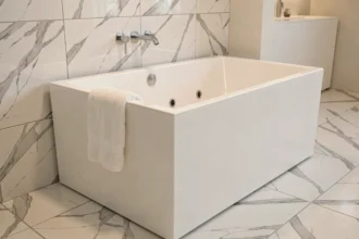 Baignoire rectangulaire balnéo encastrée avec jets hydromassants dans une salle de bain rénovée en marbre blanc